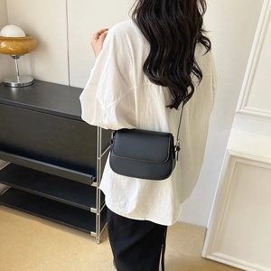 Classic black leather saddle bag for women shown in a minimalist modern commuting style