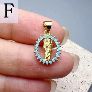 Macro view of a gold Jesus pendant with sparkling blue zircons held in hand