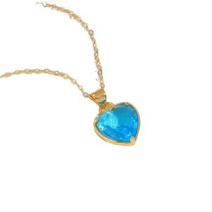 Classic gold chain necklace with a light blue heart-shaped glass pendant in a minimalist style