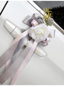 Detail of white Austin rose car door handle flower with long pink and grey ribbons