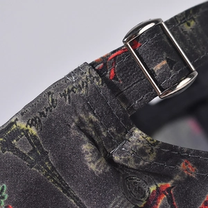 Detail of metal buckle and floral print on grey canvas baseball cap back strap