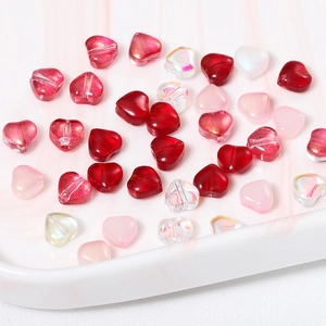 Vue macro de perles en verre en forme de cœur pour bijoux DIY et pompons artisanaux