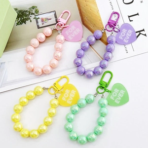 Close-up of beaded wristlet straps with heart charms in pink, purple, yellow, and green