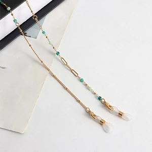 Detail of gold metal eyewear chain with teal beads and white silicone loop ends