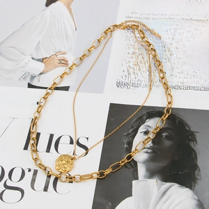 Detail of gold double layer necklace with bee pendant on oval link chain for women