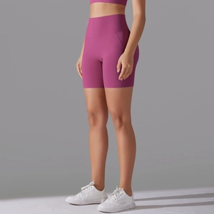 Detail of rose red high-waisted yoga shorts featuring side pockets and slimming seams