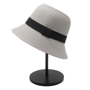 Close-up of light grey woven straw bucket hat featuring a black ribbon bow detail