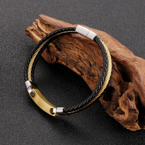 Detail of men's multi-layer braided leather bracelet with gold metal accents and magnetic clasp
