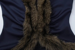 Detail view showing blue smooth fabric and brown faux fur patchwork texture on the jacket