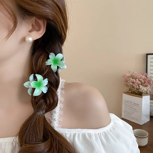 Blue-green gradient flower hair clip styled in a side-braided hairstyle for a fresh look