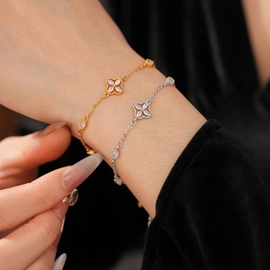 Close-up of gold and silver flower bracelets with marquise zircons on a wrist