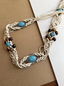 Detailed texture of bohemian waist chain with hand-woven cotton rope and turquoise beads