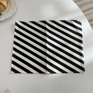 Detailansicht eines minimalistischen schwarz-weiß diagonal gestreiften Stoff-Tischsets