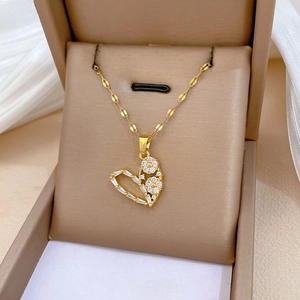 Detailed close-up of a gold hollow heart pendant with sparkling crystals in a jewelry box