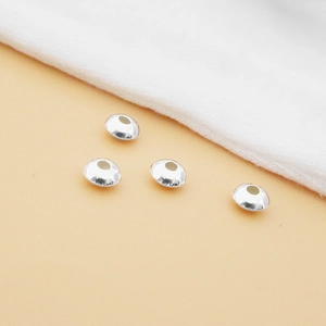 Detalle de cuatro cuentas espaciadoras de plata de ley S925 para la creación de joyería