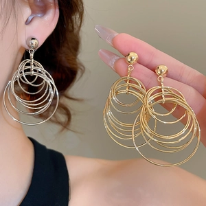 Detail view of stylish multi-layered circular hoop earrings in gold and silver finishes