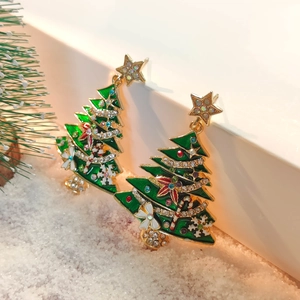 Detail view of gold-trimmed green enamel Christmas tree earrings with colorful rhinestones