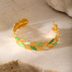 Golden laurel leaf open bangle with green and white enamel details on a stone base