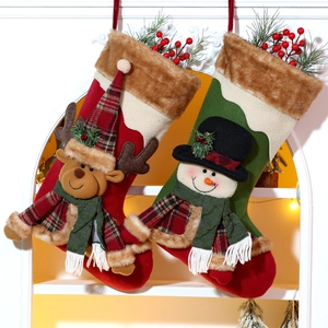 Detail of plush Christmas stockings with 3D reindeer and snowman hanging on a rack