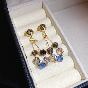 Macro view of crystal beaded earrings featuring gold hardware and faceted gradient beads