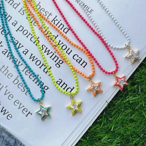 Close-up of five colorful beaded necklaces with star pendants on an open book background