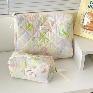 Close-up of quilted butterfly pattern makeup bags in soft pastel macaron colors