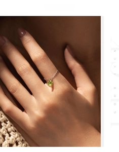 Detail of S925 silver chain ring featuring a sparkling olive green gemstone pendant