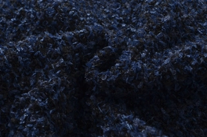 Macro della trama del tessuto bouclé blu navy che mostra i dettagli dell'intreccio