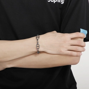 Detail of vintage industrial chain bracelet with flat D-ring buckle on a male model's wrist