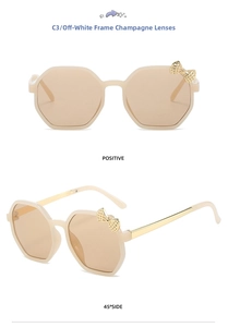 Detail view of octagon kids sunglasses in cream white with gold bow decoration