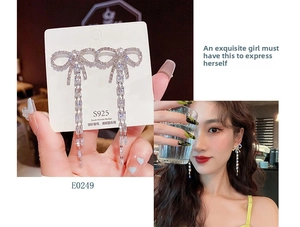 Detail of silver bow earrings with cascading tassel fringe and sparkling cubic zirconia