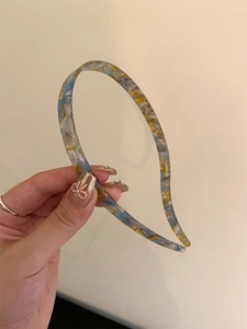 Close-up of translucent leopard print headband with blue and yellow acrylic texture
