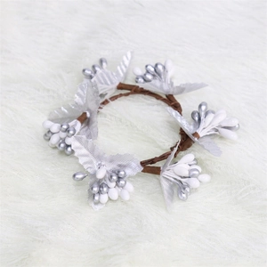 Macro view of silver berry napkin ring with brown twig wreath and metallic leaf detail