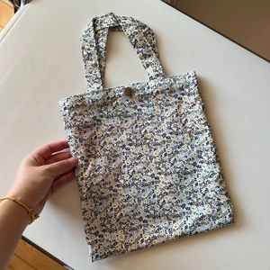 Close-up of floral cotton handbag showing fabric texture and vintage button closure
