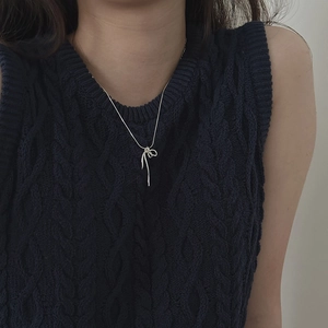 Elegant S925 sterling silver ribbon bow necklace on model with sleek snake bone chain