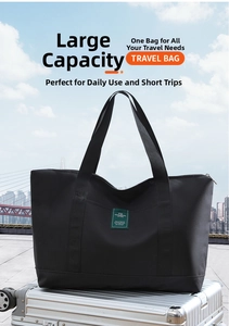 Close-up of a black canvas travel bag with green label placed on a silver suitcase