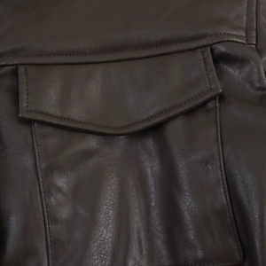Close-up of deep brown faux leather jacket showing pocket detail and fine stitching