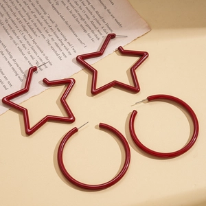 Minimalist red acrylic star and circular hoop earrings on a vintage artistic background
