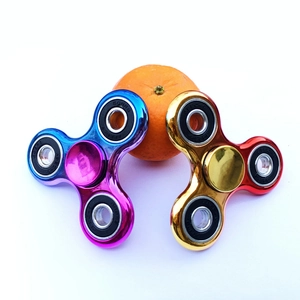 Close-up of three-arm metal fidget spinners with high-speed ABEC-7 bearings on a white surface