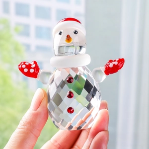Detail of faceted glass snowman crystal figurine with a festive red hat and gloves
