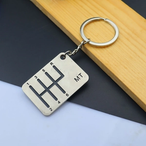 Detailed engraving of manual gear shift pattern and MT logo on metal car keychain