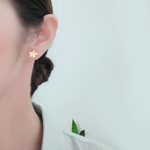 Elegant gold flower stud earrings in S925 sterling silver worn by a model