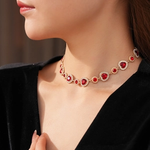 Dettaglio della collana vintage a cuore con gemme rosse e metallo dorato sul collo