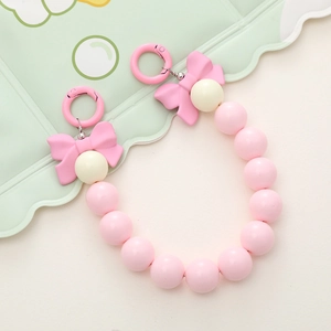 Detailed shot of pink beads and bow charm with metallic round spring buckles
