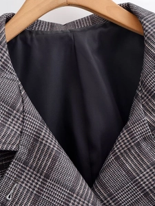 Close-up of a plaid jacket collar with premium black lining on a wooden hanger