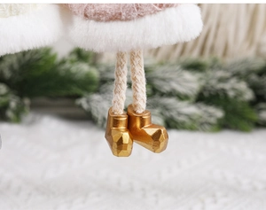Macro shot of plush Christmas angel ornament with pink knit and shiny gold boots