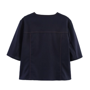 Detail view of navy blue top with contrast orange stitching and structured back panel