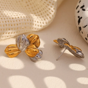 Macro shot of two-tone flower earrings in gold and silver finish with detailed petals