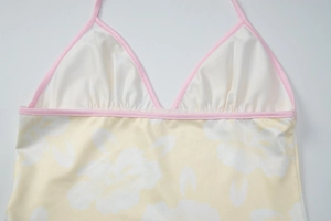 Close-up detail of floral print fabric and pink trim on a halter neck summer top