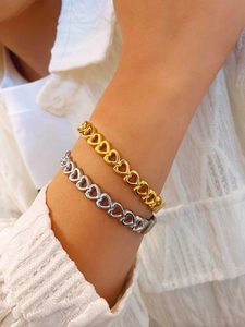 Detailed view of elegant gold and silver hollow heart chain bracelets on wrist